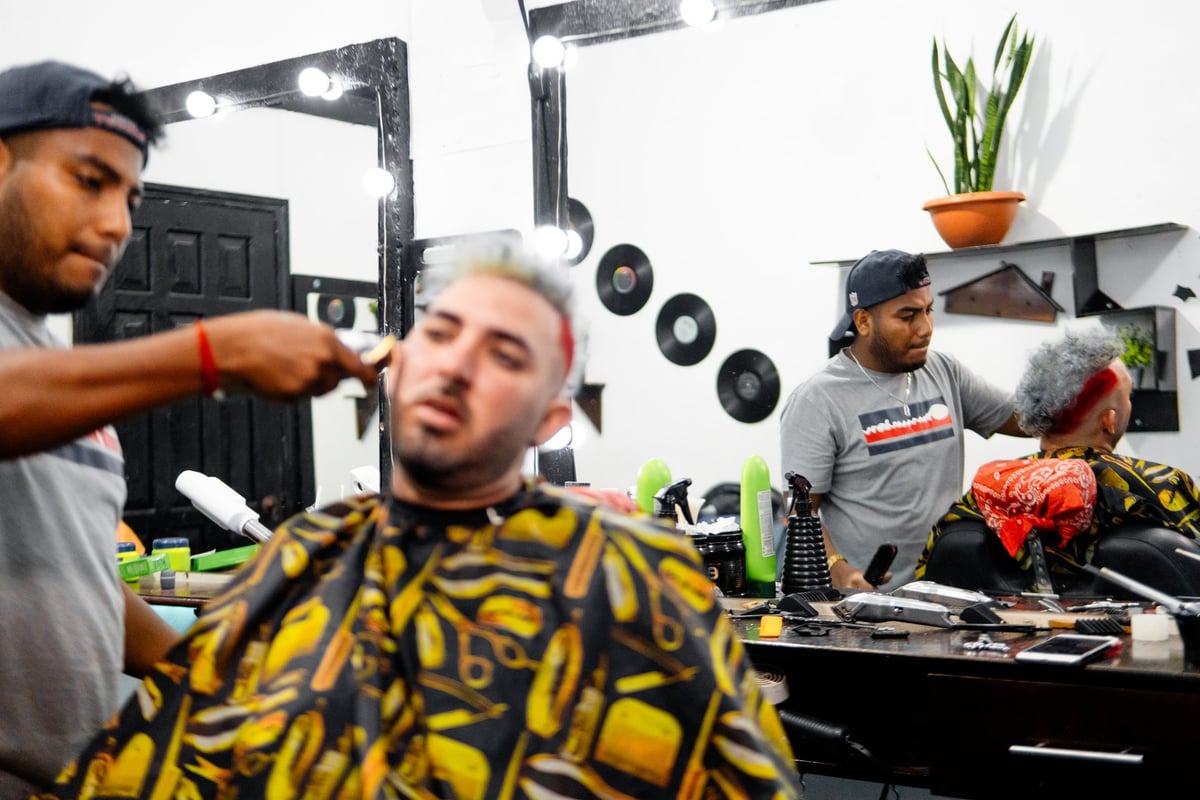 Barbers cutting hair of customers in a barbershop
