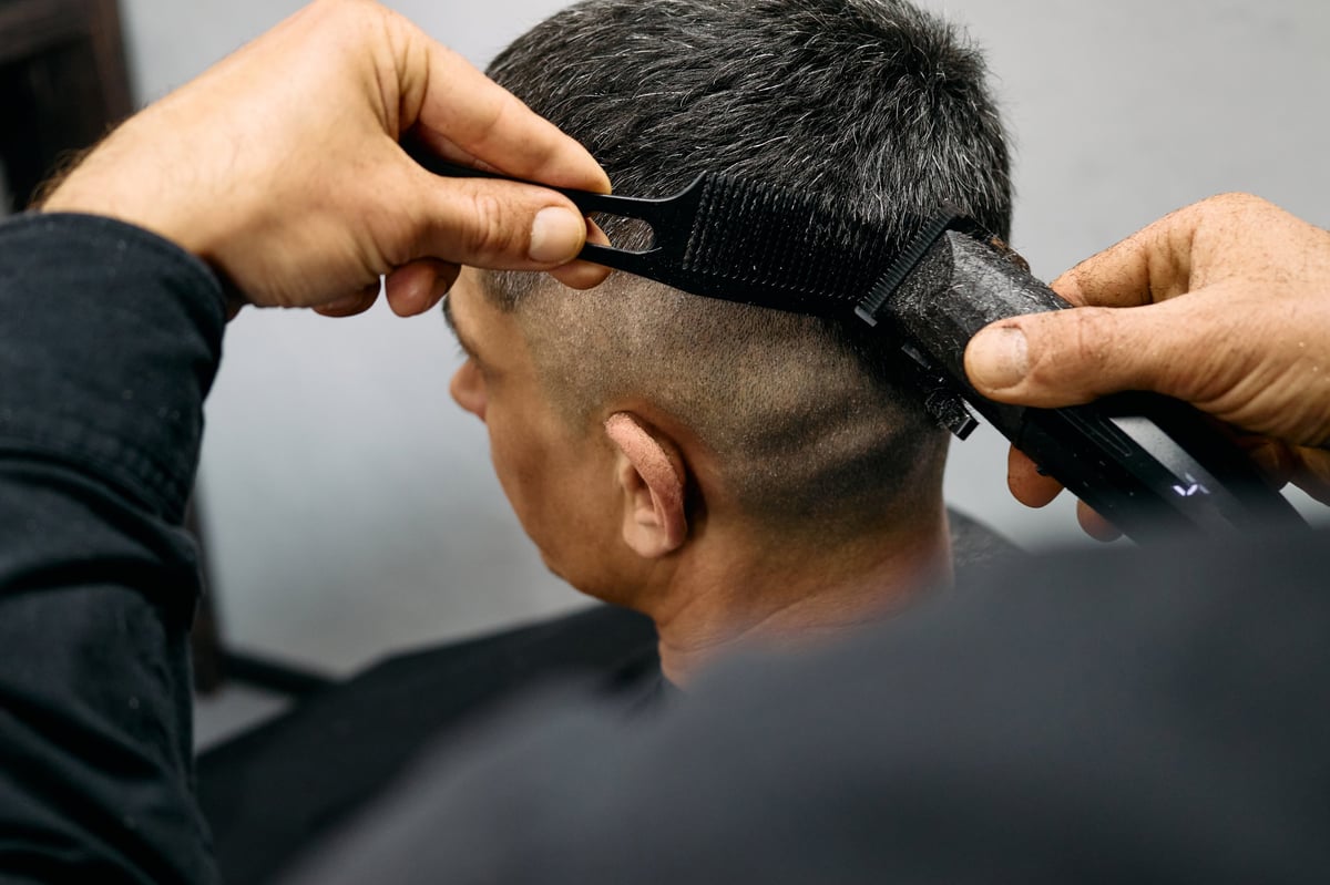Barber cutting a smooth fade with clippers