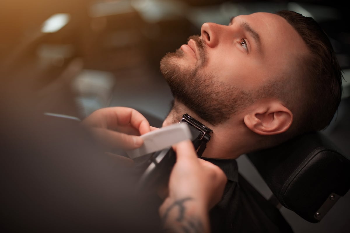 Close-up of a precise neck and beard trim with clippers